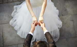 young asian newlywed couple wearing wedding dress dancing in open ground, high angle view.