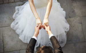 young asian newlywed couple wearing wedding dress dancing in open ground, high angle view.