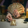Tarot cards on fortune teller desk table. Future reading. Woman fortune teller holding and hands a deck of tarot cards and shuffles it.
